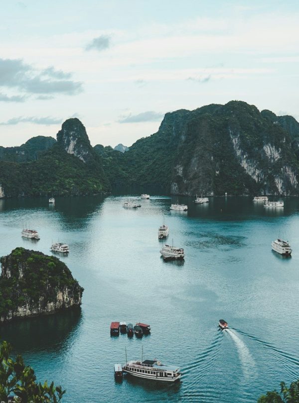 high-angle photography of boats on water near hill during daytime
